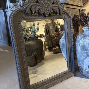 Sobere spiegel met houtsnijwerk