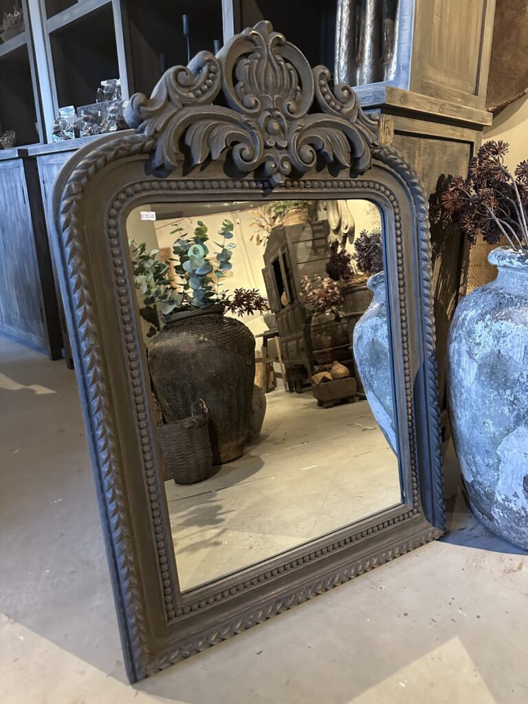 Sobere spiegel met houtsnijwerk