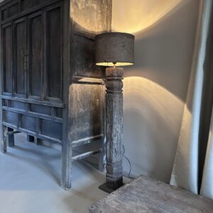 Deze unieke vloerlamp combineert de robuuste charme van historisch India met een organische, moderne afwerking. De voet van de lamp is vervaardigd uit een authentieke, oude houten pilaar uit India, waardoor elk exemplaar zijn eigen verhaal en unieke houtsnijwerk heeft. De lamp wordt gecompleteerd door een prachtige, handgemaakte leem lampenkap. Het natuurlijke materiaal van de kap zorgt voor een warme, sfeervolle lichtinval die direct rust en karakter in je woonkamer, hal of slaapkamer brengt. Specificaties: • Hoogte: 124,5 cm (ideale hoogte voor naast een bank of in een hoek) • Diameter kap: 30 cm • Materiaal voet: Antiek hout (originele Indiase pilaar) • Materiaal kap: Leem / Stuc-look • Stijl: Wabi-sabi, sober wonen, landelijk, industrieel of bohemien Belangrijke informatie: Vanwege de kwetsbaarheid van de leemkap en het gewicht van de antieke pilaar kan deze lamp niet verzonden worden. De lamp is uitsluitend op te halen in onze showroom/winkel.